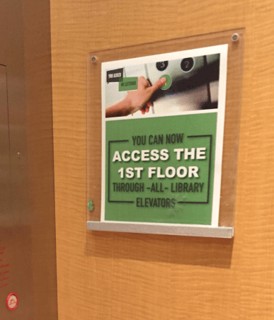 sign reading 'you can now access the 1st floor through all library elevators"